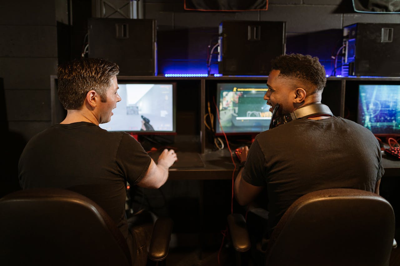 hero-img-01 Two men engaged in an exciting gaming session in a modern cyber cafe.